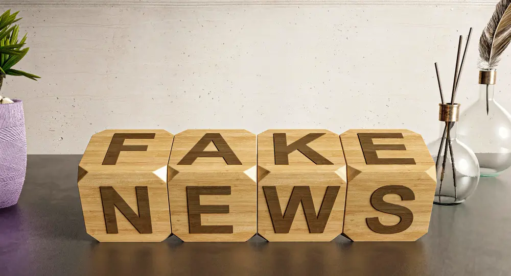 cubos de madeira sobre a mesa com a palavra fake news