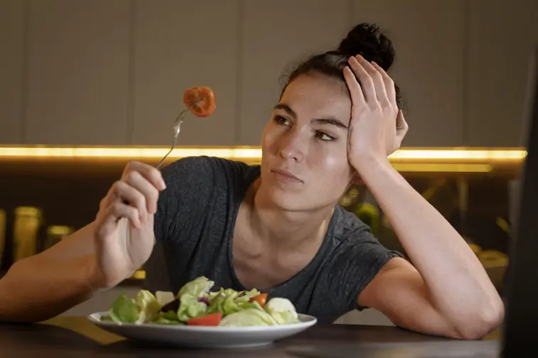 imagem de mulher tentando comer saudável em casa